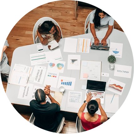 Top view of a team analyzing graphs and documents for SEO strategy planning.